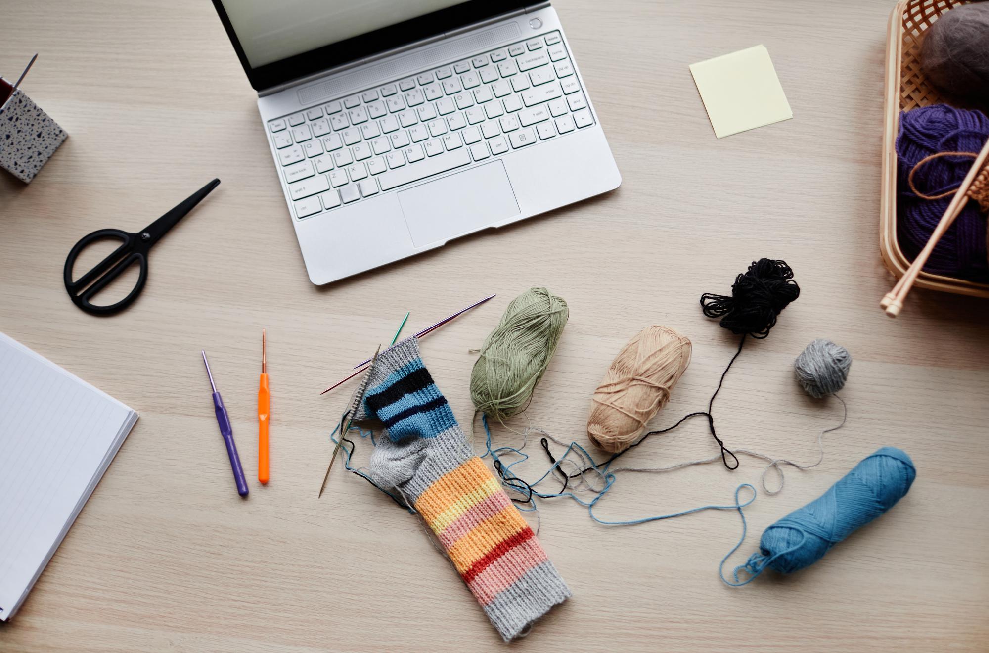 Flatlay of threads, needles and pattern sketches